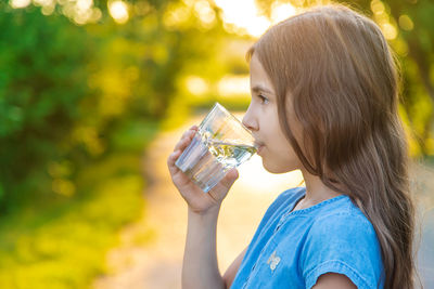 Girl drinking water at park