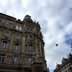 Low angle view of building against cloudy sky