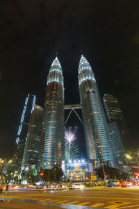 Illuminated modern buildings against sky at night