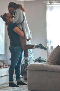 Woman standing on sofa at home