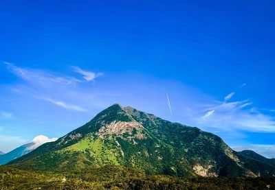 Scenic view of mountain against blue sky