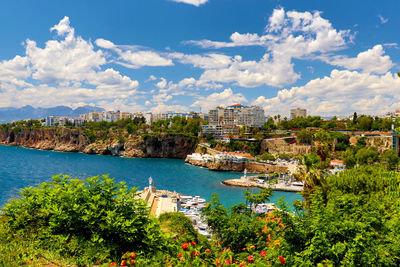 High angle view of buildings by sea against sky