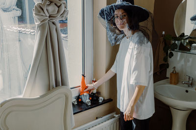 One teenage girl lies a halloween gnome on the windowsill.