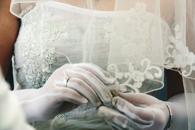 Midsection of bride holding wedding ring