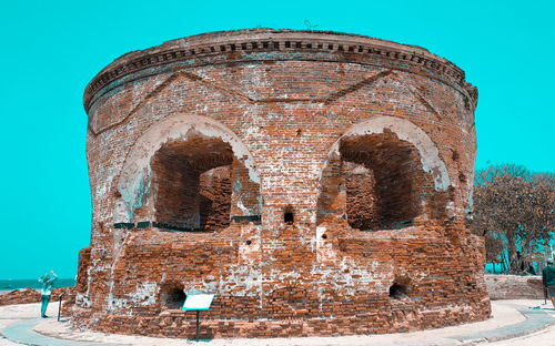 Low angle view of old abandoned building against clear blue sky