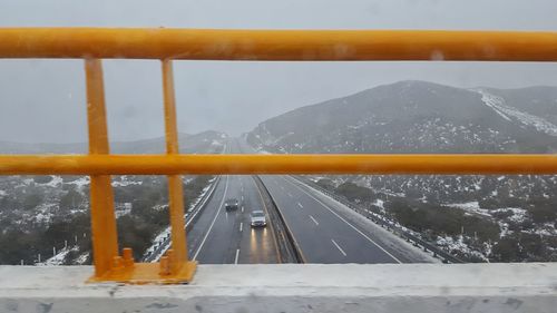 Road by mountain against sky during winter