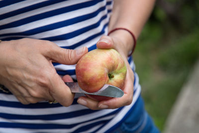 Midsection of man holding apple