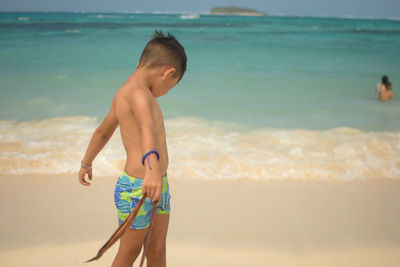 Full length of shirtless boy on beach