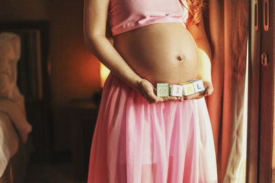 Midsection of woman standing at home