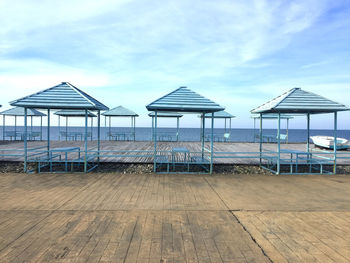 Pavilion on beach against blue sky