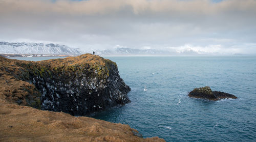 Scenic view of rocks in sea against sky