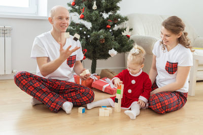 Portrait of siblings sitting on sofa at home