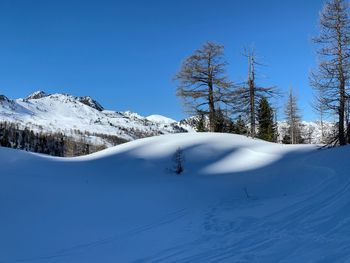 Scenic view of snow covered mountains against clear blue sky