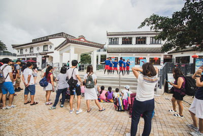 People at town square against sky in city