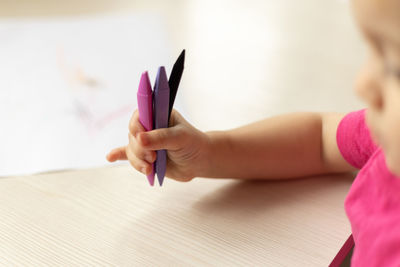 Midsection of boy drawing on book at table