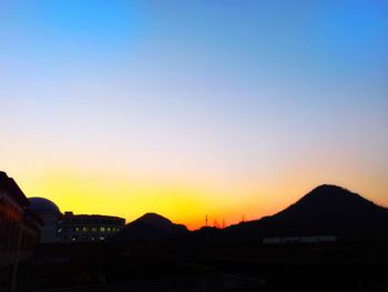 Silhouette buildings against sky during sunset