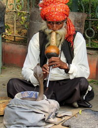 Full length of man sitting outdoors