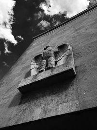 Low angle view of sculpture on roof against sky