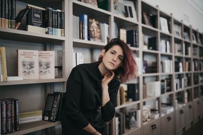Portrait of young woman standing in open book