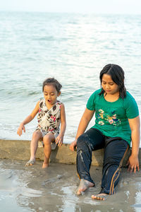 Portrait of siblings sitting at beach