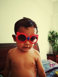 Portrait of shirtless boy sitting at home