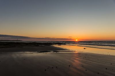 Scenic view of beach against sky during sunset