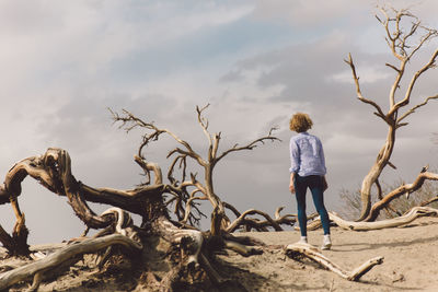 Rear view of young woman standing on beach