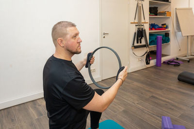 Male fitness pilates trainer shows exercises on special simulators. rubber rings for stretching