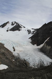 Low angle view of snowcapped mountains against sky