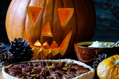Carved pumpkin and pumkin pie with pecans