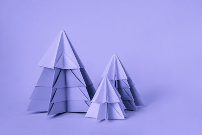 Simple origamy 3d christmas tree made from paper toned violet color