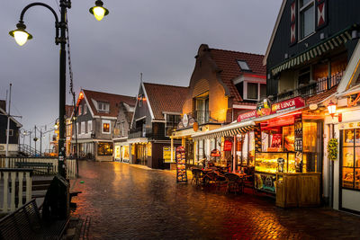 Street amidst buildings against sky at dusk