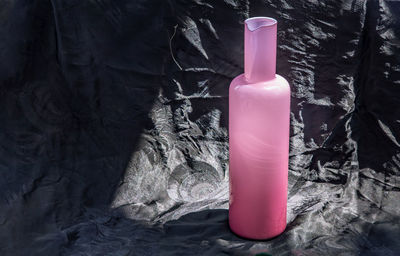 Close-up of bottle against pink water