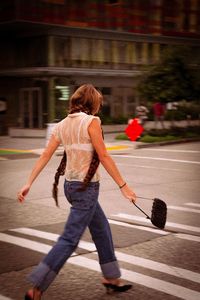Rear view of woman walking on road