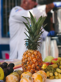 Close-up of fruits on table with man standing in background