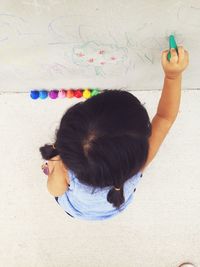 High angle view of girl drawing on wall