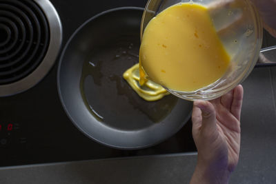 Pouring egg mixture into frying pan