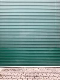 Closed green shutter by walkway