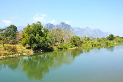 Scenic view of lake by trees against sky