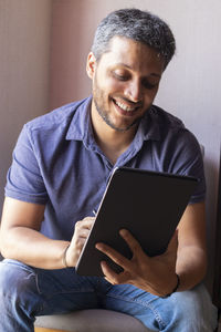 Young man using mobile phone at home