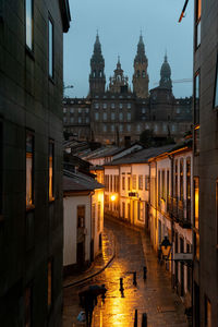 At night, the illuminated cathedral in santiago de compostela, spain, shines under a full moon