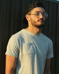 Close-up of young man wearing sunglasses standing outdoors