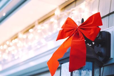 Close-up of red tied bow on lamp during christmas