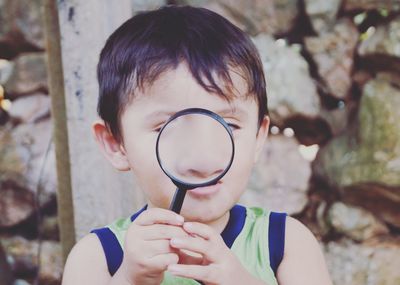 Close-up of boy playing with magnifying glass