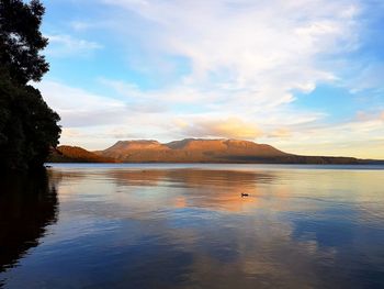 Scenic view of lake against sky at sunset