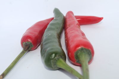 Close-up of chili peppers over white background