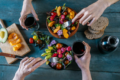 High angle view of hand holding fruits on cutting board