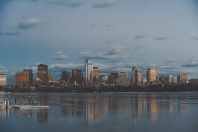 Sea by buildings against sky in city