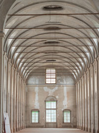 Empty white interiors without people in an old hospital building in parma, italy.