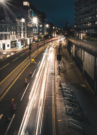 Light trails on road along buildings at night